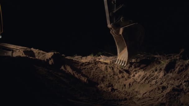 Kotró ásás homok és a por, éjjel, útépítés során működő közelről lövés a vödör a föld mozgató gép, az éjszakai munka, a túlóra ásás — Stock videók