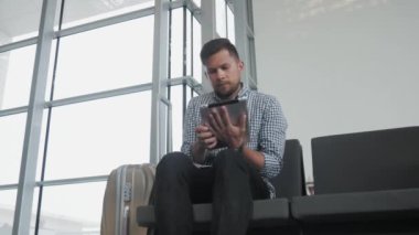 Yakışıklı genç Holding Tablet Pc ve çalışma havaalanında, teknoloji, kavram seyahat