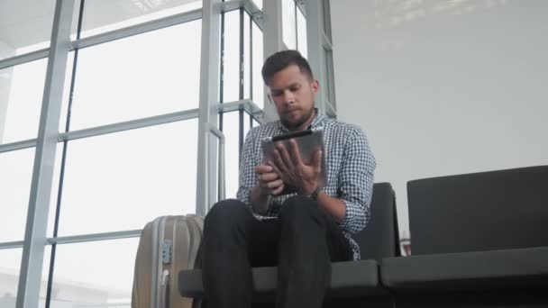 Guapo joven sosteniendo la tableta PC y trabajando en el aeropuerto, tecnología, concepto de viaje — Vídeo de stock