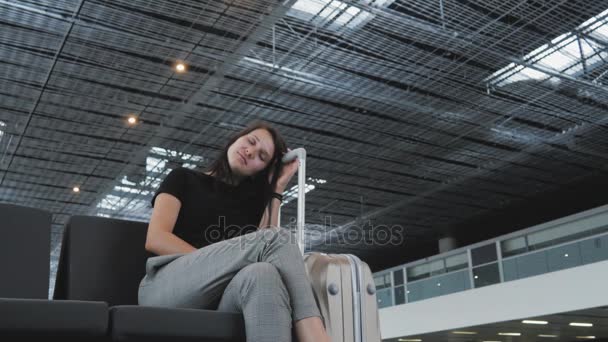 Bela morena está dormindo enquanto espera para a fila para check-in no o aeroporto — Vídeo de Stock