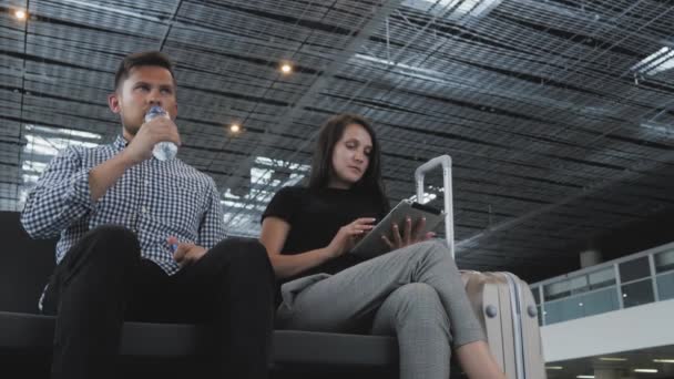 Un paio di turisti usano i loro gadget in attesa della coda per il check-in in aeroporto, tecnologia, concetto di viaggio — Video Stock