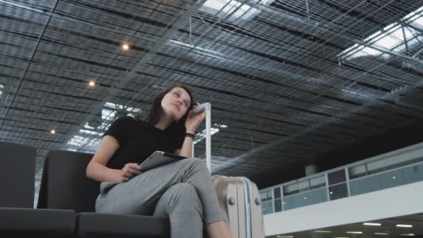 Jonge mooie zakenvrouw met een Tablet Pc op luchthaven terwijl haar wachtrij wachten op registratie, reizen Concept — Stockvideo