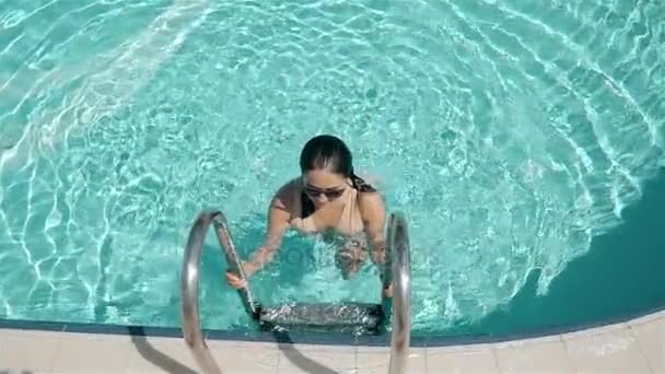 Retrato de una joven atractiva saliendo de la piscina al aire libre . — Vídeos de Stock