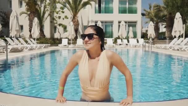 Портрет привлекательной молодой женщины, выходящей из бассейна на открытом воздухе . — стоковое видео