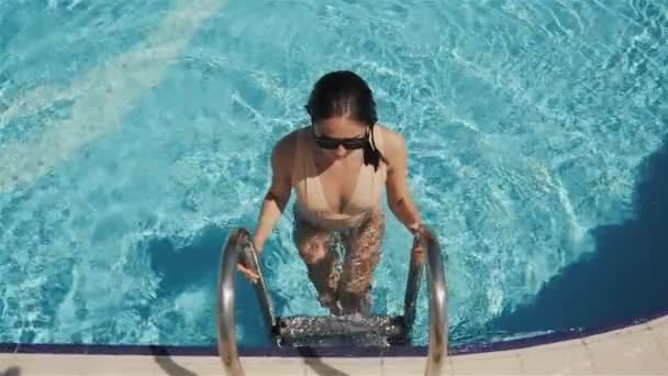 Πορτρέτο του ελκυστική νεαρή γυναίκα που βγαίνει από την πισίνα σε εξωτερικούς χώρους. — Αρχείο Βίντεο
