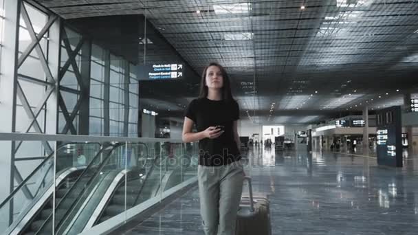 Молода красива бізнес-леді, використовуючи смартфон в аеропорту, чекаючи її черги для реєстрації, концепція подорожі — стокове відео