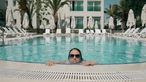 Sexy meisje komt omhoog uit de Pool. Zomervakantie In het Resort, meisje zwemt In het heldere water van het zwembad, mooie glimlach — Stockvideo
