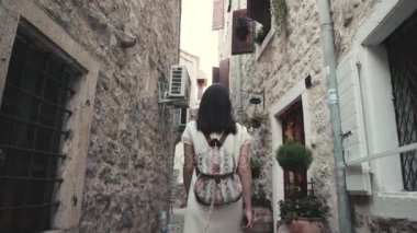 Old Town, sokakta yürüyen genç kadın portresi açık hava yaşam tarzı sırt çantası, şık Casual kıyafet, akşam Günbatımı ile seyahat