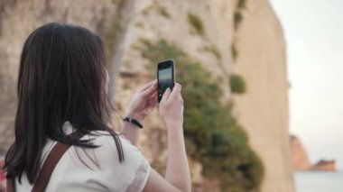 Yong kadın yanında Smartphone fotoğraf çekmek. Şık yaz Traveler kadınla telefon Avrupa şehirde açık havada, Old Town içinde belgili tanımlık geçmiş