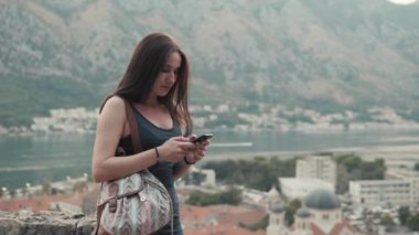 Smartphone, sırt çantası, şık Casual kıyafet, akşam Günbatımı ile seyahat kullanan genç kadın portresi açık hava yaşam tarzı