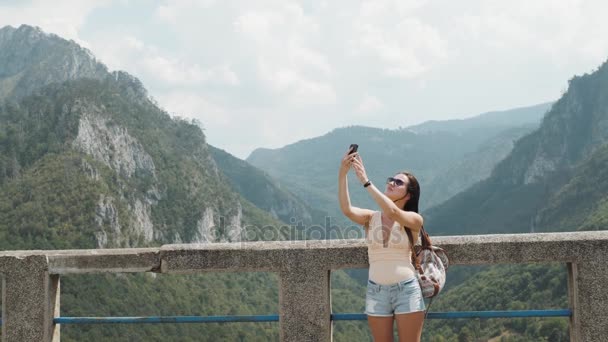 Туристичні Selfie дівчина рішень по телефону Djurdjevic мосту в Чорногорії, подорожувати способу життя — стокове відео