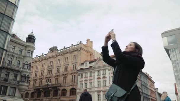 Красива молода жінка турист в Празі, створення селфі або фотографії з її мобільним телефоном, концепція подорожі — стокове відео