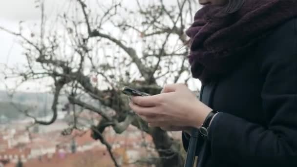 Detailní záběr Zenske rukou pomocí Smartphone sedí na lavičce v parku. Krásná dívka Evropské textové zprávy na telefonu — Stock video