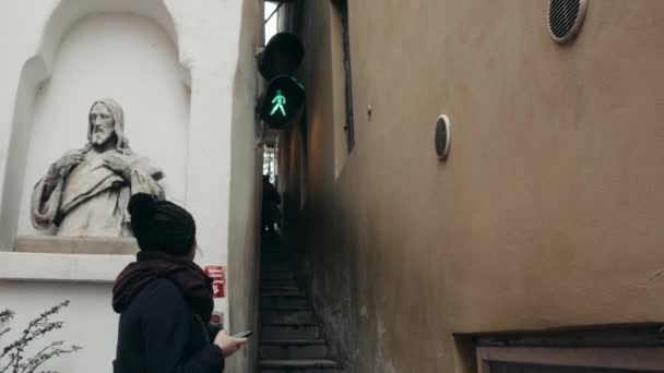 ヨーロッパ、プラハ、チェコ共和国で最も狭い路上を歩く若い女性 — ストック動画