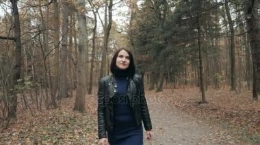 Sonbahar parkta yürüyen genç güzel kadın. Kız ormanda yürüyüş sonbaharda, yaşam kavramı