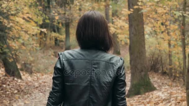 Giovane bella donna a piedi nel parco autunnale. Ragazza che cammina nella foresta in autunno, concetto di stile di vita — Video Stock