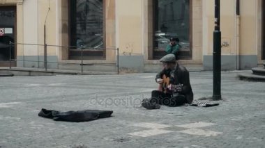 İskambil gitar ve şarkı müzik Prag, Çek Cumhuriyeti - 26 Ekim 2017 yakışıklı adam müzisyen. A sokak müzisyen, bir genç adam oturur Caddesi ve gitar için söylüyor