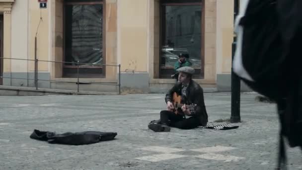 Prága, Csehország - október 26, 2017-ig, jóképű férfi zenész játszik a gitár és az ének-zene. Egy utcai zenész, egy fiatalember ül az utcán, és énekel a gitár — Stock videók