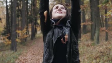 Sonbahar ile oynarken mutlu bir genç kadın portresi ormanda bırakır