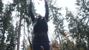 Sonbahar ile oynarken mutlu bir genç kadın portresi ormanda bırakır