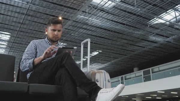 Przystojny, młody człowiek gospodarstwa Tablet Pc i pracy na lotnisku, technologia, podróży koncepcja Zdjęcie Stockowe