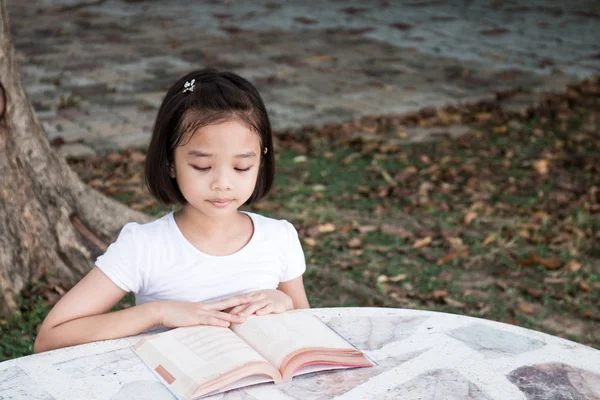 küçük Asyalı çocuk açık bir kitap okuma