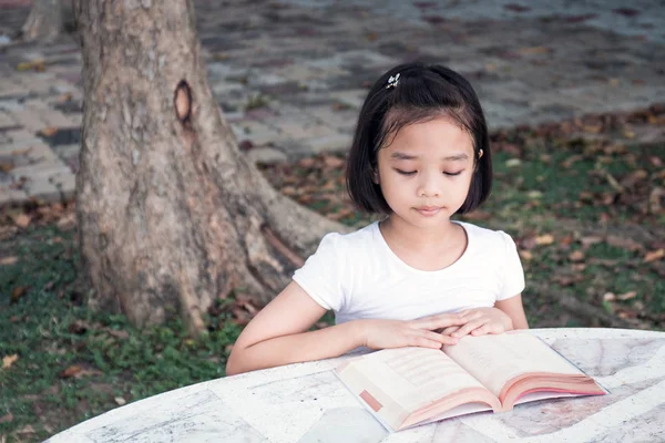 küçük Asyalı çocuk açık bir kitap okuma