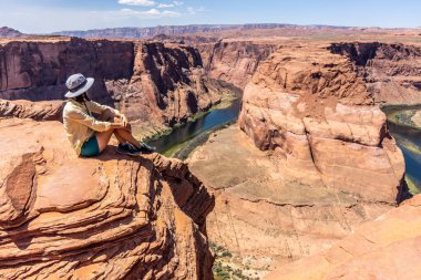 Arizona, Horseshoe Bend 'in kenarında oturan kız.