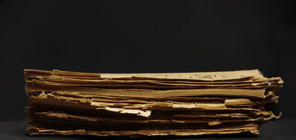 Stack old yellow paper on a dark background — Stock Photo, Image