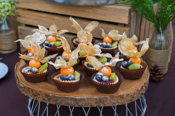 Tatlı tartlets dekorasyonu ile masaya taze çilek ile. Tatlı kek açık havada için parti.