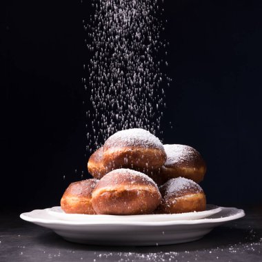 siyah arka plan üzerine pudralanmaya tatlı çörek