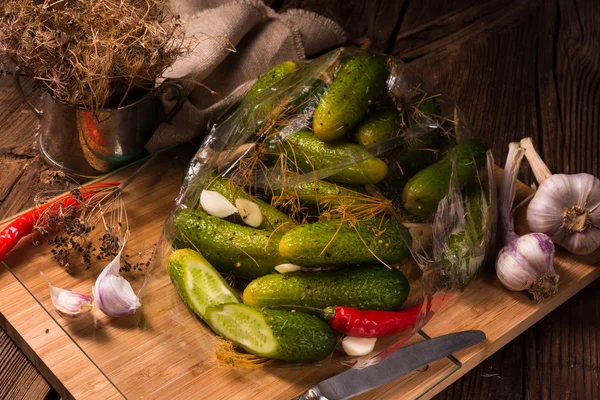 Salt cucumbers on wooden cutting board — Stock Photo, Image