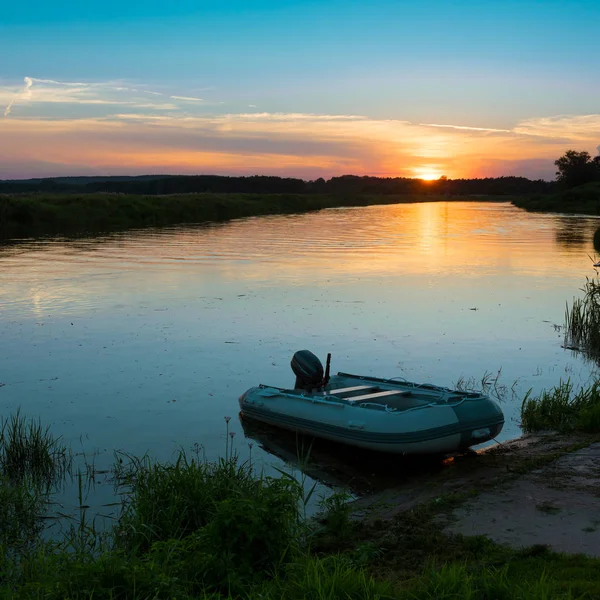 Båt vid stranden av sjön vid solnedgången — Stockfoto