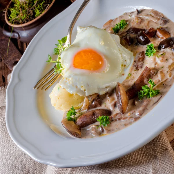 Грибы с картофелем и яйцом на тарелке — стоковое фото