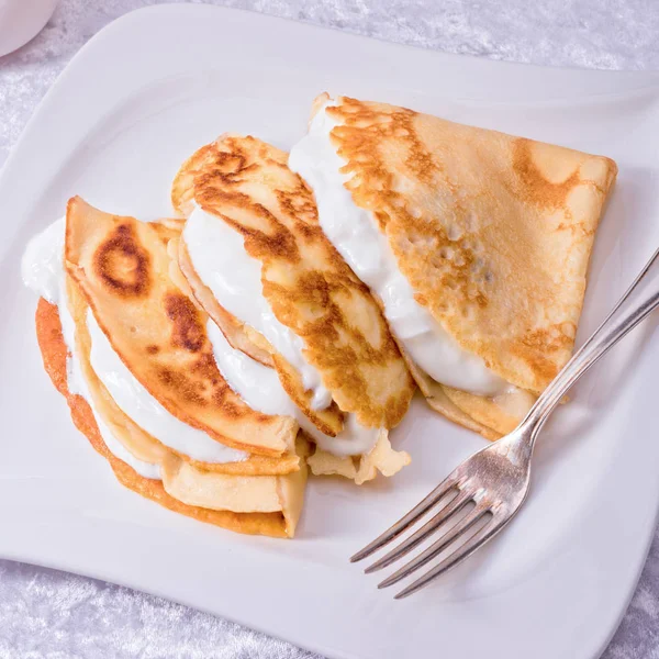 Crepes with sour cream — Stock Photo, Image