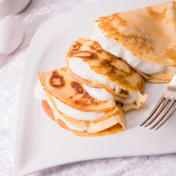 Crepes with sour cream — Stock Photo, Image
