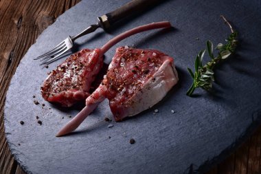 karanlık taş zemin üzerine taze çiğ kuzu pirzolası