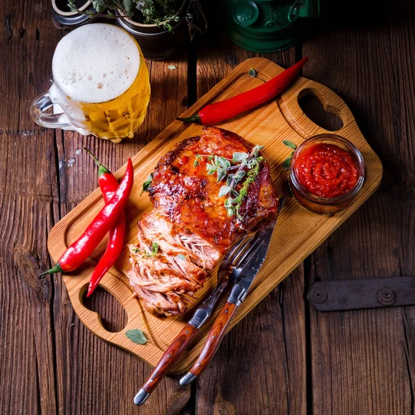 beer and tasty Barbecue pulled pork on wooden cutting board