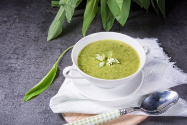 Beyaz tabak içinde yeşil yabani sarımsak çorbası 