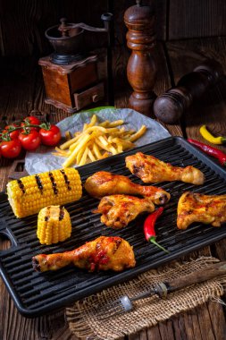 Rustik ızgara tavuk kanatlar, bacaklar ve baharatlı Mısır