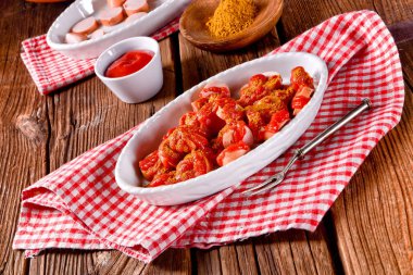 Köri soslu beyaz tabak içinde sosis