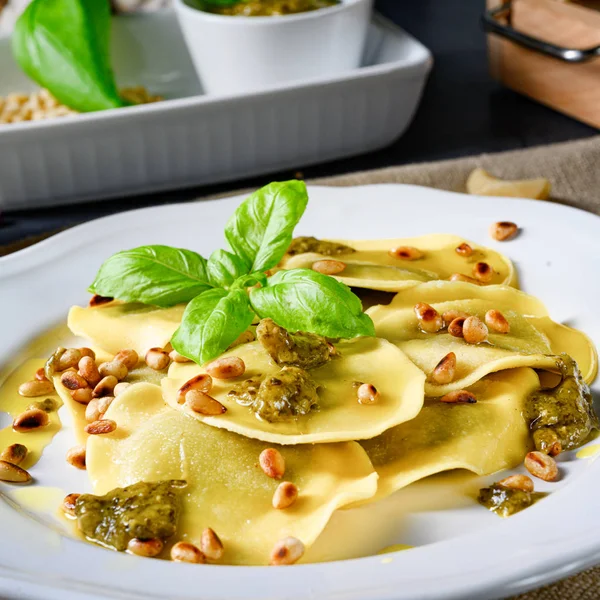 Vegetarianskt italiano! Tortelli med rostade pinjenötter och pesto — Stockfoto