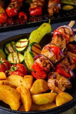 Şiş kebap, çeşitli sebzeler ve baharatlı patates.