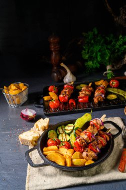 Şiş kebap, çeşitli sebzeler ve baharatlı patates.
