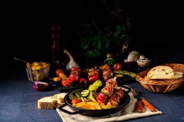 Şiş kebap, çeşitli sebzeler ve baharatlı patates.