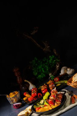 Şiş kebap, çeşitli sebzeler ve baharatlı patates.
