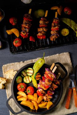 Şiş kebap, çeşitli sebzeler ve baharatlı patates.