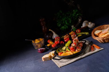 Şiş kebap, çeşitli sebzeler ve baharatlı patates.