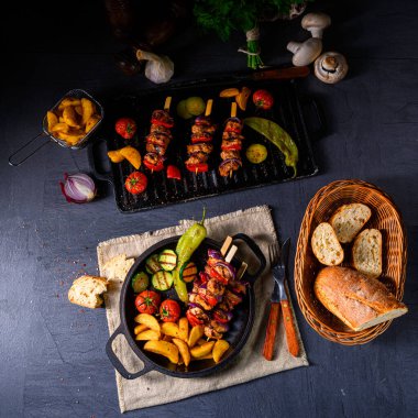 Şiş kebap, çeşitli sebzeler ve baharatlı patates.