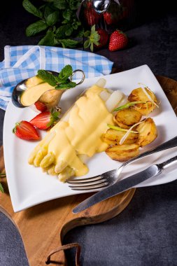 Kızarmış patates ve holandez soslu kuşkonmaz.